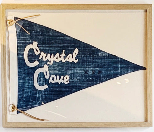 Framed horizontal navy pennant with ivory lettering that spells Crystal Cove
