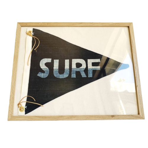 Dark navy pennant flag in a salt oak frame featuring hand cut denim lettering that spells SURF in a horizontal orientation