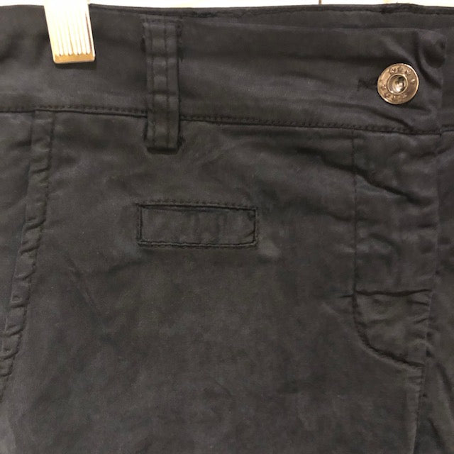 close up of the waistband of black pants with button/zipper, pant loop, small front pocket, larger front pocket with diagonal opening.