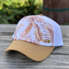 The Gidget trucker cap, by Kooringal has a white mesh back, rust color brim, and a rust color tropical palm print.
