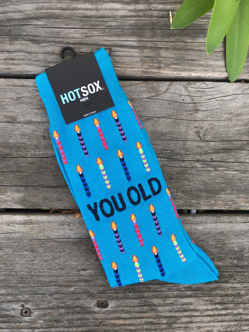 Turquoise blue men's socks with multi-colored birthday candles and the phrase 'you old'.