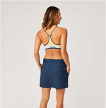 Back view of a female model wearing the Carve Designs Paddler Skirt in navy bayside, or navy blue with light blue horizontal pinstripes. Paired with bikini top.