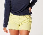 Front view of female model wearing Carve Designs Oahu shorts in citron (yellow). Shorts are corduroy with 4" inseam, front button/zipper closure, and raw hem bottom. Paired with navy blue long sleeve top.