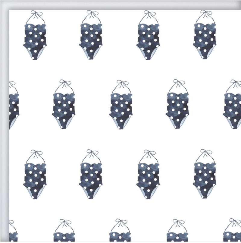 A sheet of white wrapping paper with navy blue and white polka dot bathing suits printed in a repetitive pattern.
