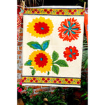 Kitchen towel in floral blockprint of reds, yellows, teals and greens.
