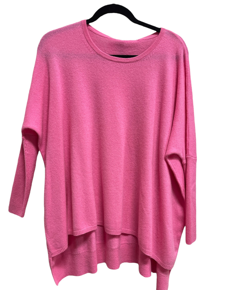 soft pink top with a round neck. the front is shorter than the back and the sleeves are ribbed at the elbow