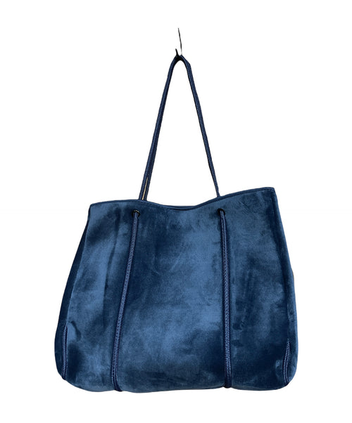 large royal blue velvety bag with narrow blue rope straps. The straps also decorate the pouch as they loop around