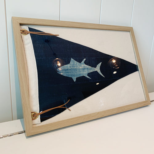 Navy pennant flag with light blue tuna design, leather ties and gold grommets, mounted on natural canvas and framed in a salt oak frame