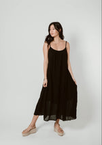 black supremely comfortable spaghetti strap dress with rounded neck that reaches mid calf on model.