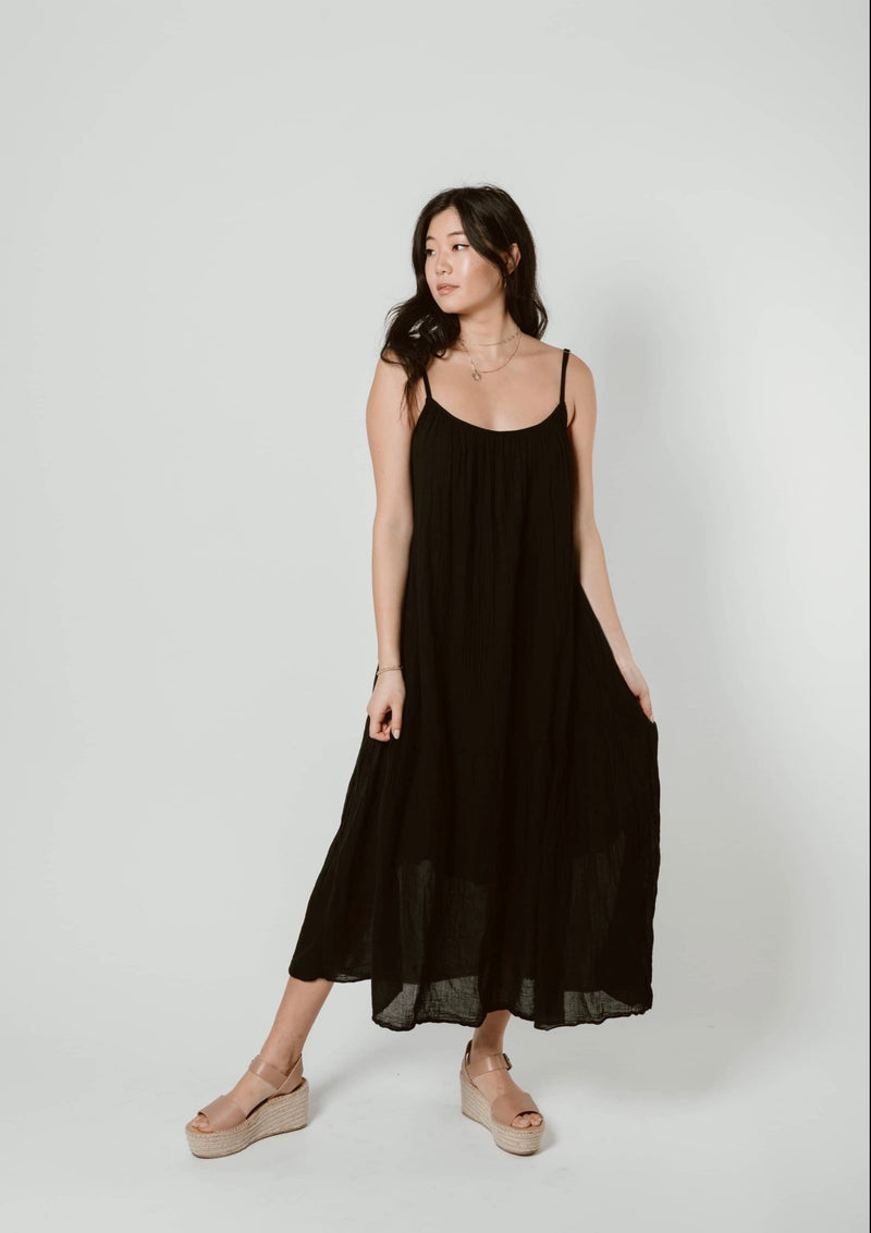 black supremely comfortable spaghetti strap dress with rounded neck that reaches mid calf on model.