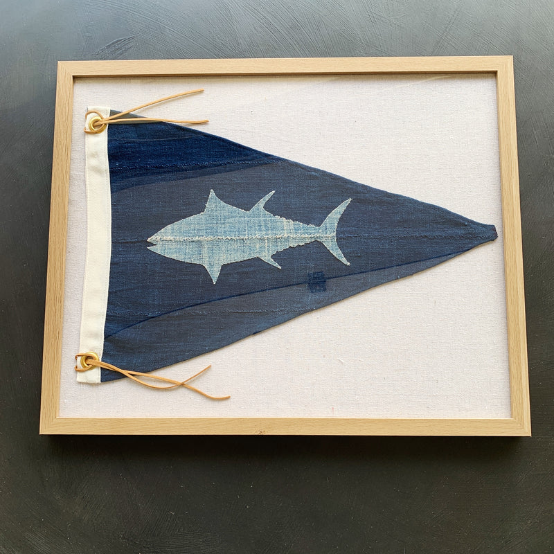 Framed horizontal navy pennant flag with light blue fish design, framed in a salt oak frame.